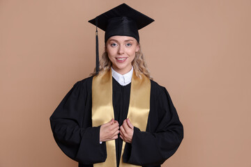 Happy student after graduation on beige background