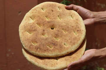 Hands holding a traditional moroccan bread, Khobz Close Up