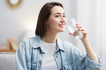 Young woman drinking water from at home