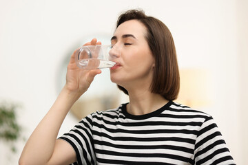 Young woman drinking water from at home