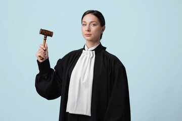 Judge with mallet on light blue background