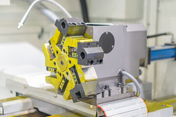 Close-up view of an industrial machine in a factory setting, featuring mechanical parts like gears and levers A contrasting yellow component is prominent Realistic style with emphasis on complexity