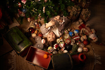 cute girl at cozy home under decorated christmas tree