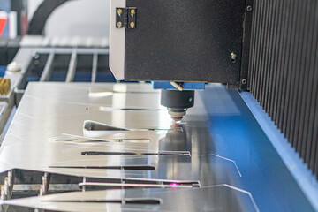 Industrial machine operation large metal press shapingcutting material, bright lighting, contrasting colors, no people present
