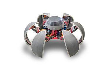 A robotic spider, powered by electricity, is depicted in shades of grey with visible wires and circuits Its eight legs resemble motors at each joint The image was shot indoors under even lighting