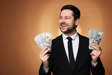 Happy greedy banker with dollar banknotes on golden background. Space for text