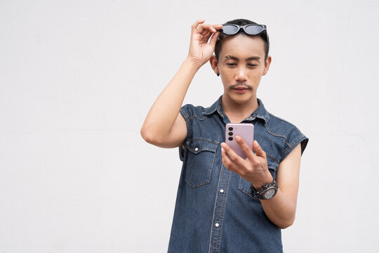 Portrait of nonbinary genderfluid young Asian gay man using phone