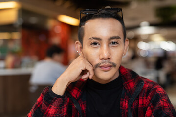 Portrait of nonbinary genderfluid young Asian gay man looking at camera
