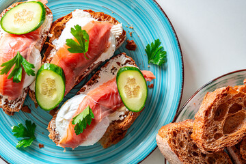 Toast with poached egg, cream cheese and red fish on a blue plate. Delicious and healthy breakfast. Top view