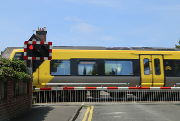 A fast moving train at the level crossing in Raven Meols Lane, Formby, Lancashire, England, UK.