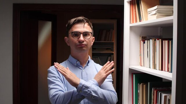 Librarian making stop sign with hands in library: access denied