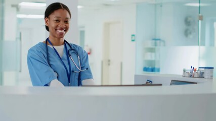 African American nurse standing at hospital reception desk, smiling. Copy space for text, healthcare and medicine concept - Powered by Adobe