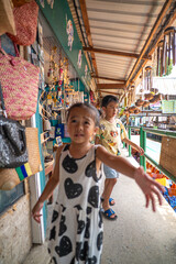 Kid enjoy buy handmade toy in souvenir shop floating market