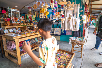 Kid enjoy buy handmade toy in souvenir shop floating market