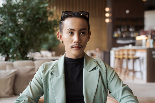 Portrait of nonbinary genderfluid young Asian gay man in coffee shop