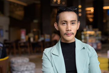 Obraz premium Portrait of nonbinary genderfluid young Asian gay man in cafe