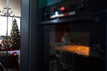Boy making homemade pizza at home in the kitchen