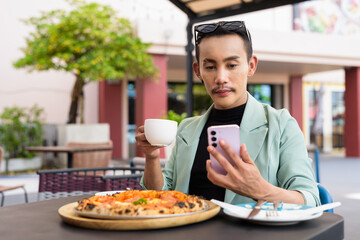 Portrait of nonbinary genderfluid young Asian gay man eating pizza ourdoors