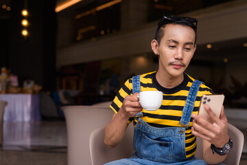 Portrait of nonbinary genderfluid young Asian gay man in coffee shop