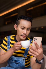 Portrait of nonbinary genderfluid young Asian gay man in coffee shop