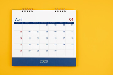 April 2026 desk calendar on the yellow table, planning for business meeting or planning concept.