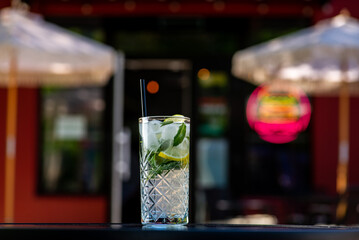 Mojito cocktail in a glass in a tall glass on a table on a summer terrace in a cafe