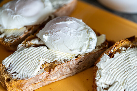 Bread toast is smeared with cottage cheese cream. Close-up.
