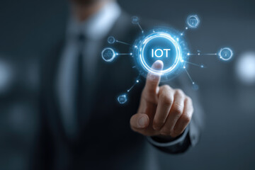 Smart business IOT, internet of things concept. Businessman touching IOT icon on virtual screen, connected internet network to access AI intelligence, business analytics, internet investing