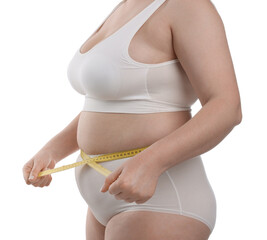 Weight loss. Plus size woman measuring waist with tape on white background, closeup