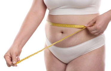 Weight loss. Plus size woman measuring waist with tape on white background, closeup