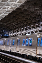 A metro train pauses beneath the striking geometric ceiling of a D.C. station.