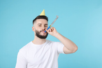 Happy Birthday. Handsome man with party hat and blower on light blue background, space for text