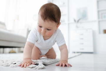 Cute little baby crawling on floor at home