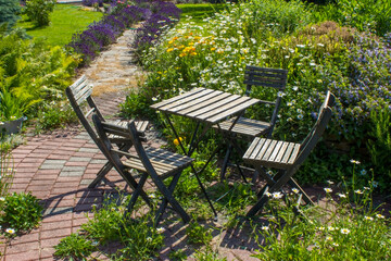 herb spiral in the garden with fresh herbs and flowers