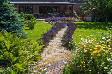 rustical garden - stone paved garden path and flowers