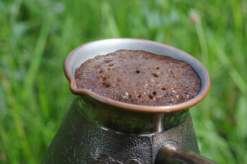 Coffee in a turkish coffee pot on a green background