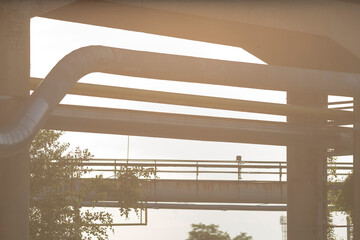 A beautifully designed bridge spanning over a serene body of water, surrounded by lush trees in the...