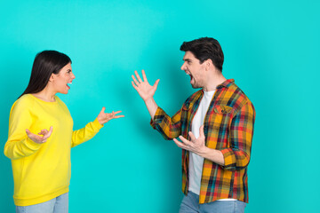 Two young people expressing emotions with hand gestures against a turquoise background capturing...