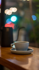 A cup of hot coffee on wooden table with bokeh background	