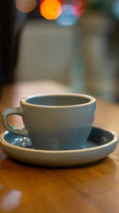 Close up of hot coffee or tea and teapot on wooden table with bokeh background	