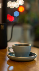 up of hot coffee or tea and teapot on wooden table with bokeh background