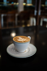 A cup of coffee latte with froth art on the table	