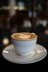 A cup of coffee latte with froth art on the table	