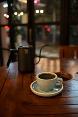 Cup of hot coffee on wooden table with bokeh background