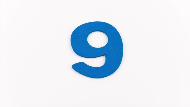 numeri realizzati in legno colorato in sequanza da 0 a 9 su sfondo bianco, stop motion