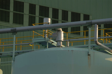 There is a large building prominently featuring numerous pipes protruding from its structure,...
