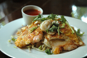Thai Style Seafood Omelette, Fresh Shrimp and Squid with Hot and Spicy Dip Sauce in White Plate.