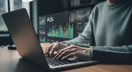 Person typing on a laptop with ads and growth charts displayed on the screen overlaying the laptop