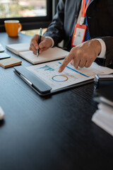 an accounting and financial officer is working on documents in the office, a businessman is reviewing his company's historical budget statistics, finance, marketing