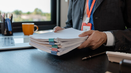 an accounting and financial officer is working on documents in the office, a businessman is reviewing his company's historical budget statistics, finance, marketing